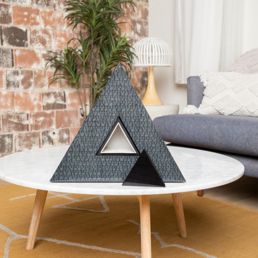 Modern triangular sculptural urn on a marble coffee table